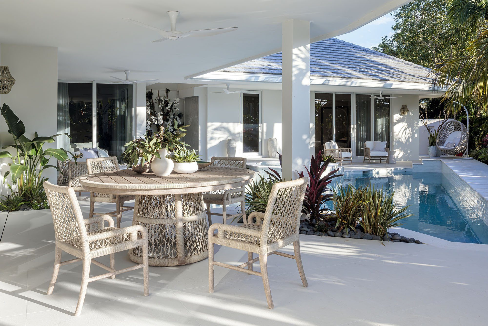 Outdoor dining terrace beside a swimming pool in a luxury South Florida home